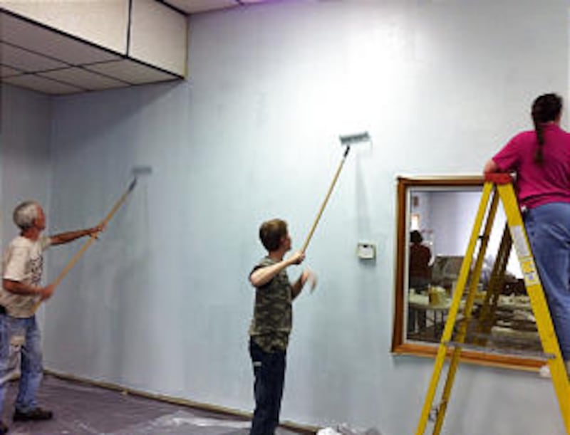A Community of Christ member, left, alongside Joplin 2nd Ward members, helps paint interior of the C