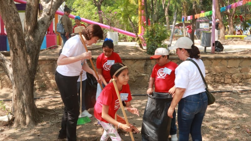 Primary General President Susan H. Porter helps children sweep a public park during a service activity in Tuxtla Gutiérrez, Chiapas, Mexico, in May 2026.