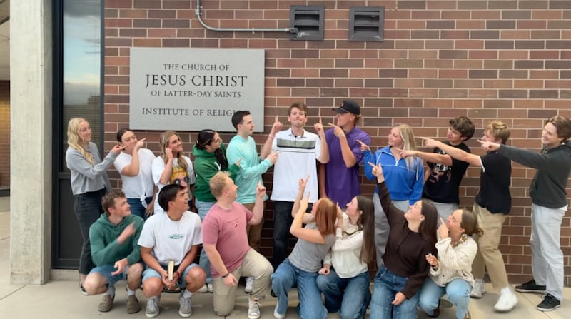Kaleb Jones, center, points heavenward while other young adults point to him in a video filmed at the Utah Valley Institute of Religion in Orem, Utah, in 2026.