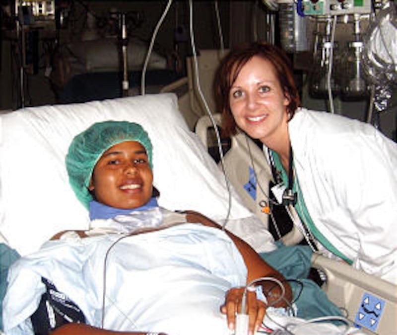 Katie Money, a neonatal intensive care nurse from Ogden, Utah, visits a teenage Haitian patient in