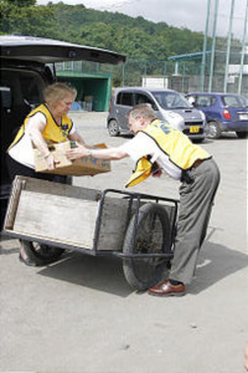 Cindy and Conan Grames, Director of public affairs for the Church's Asia North Area, take food to a