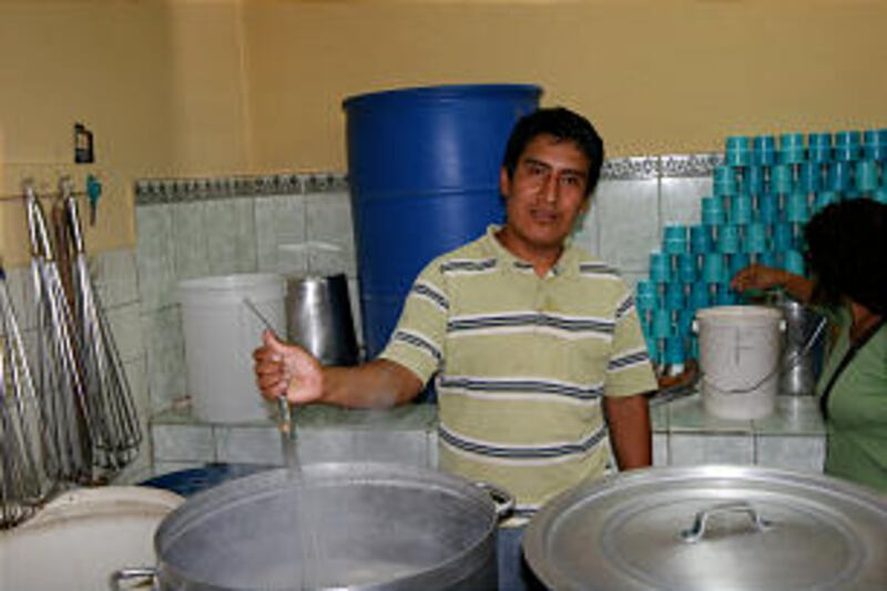 A volunteer parent stirs a huge pot of hot oatmeal in the Johannes Gutenberg Cultural Association ki