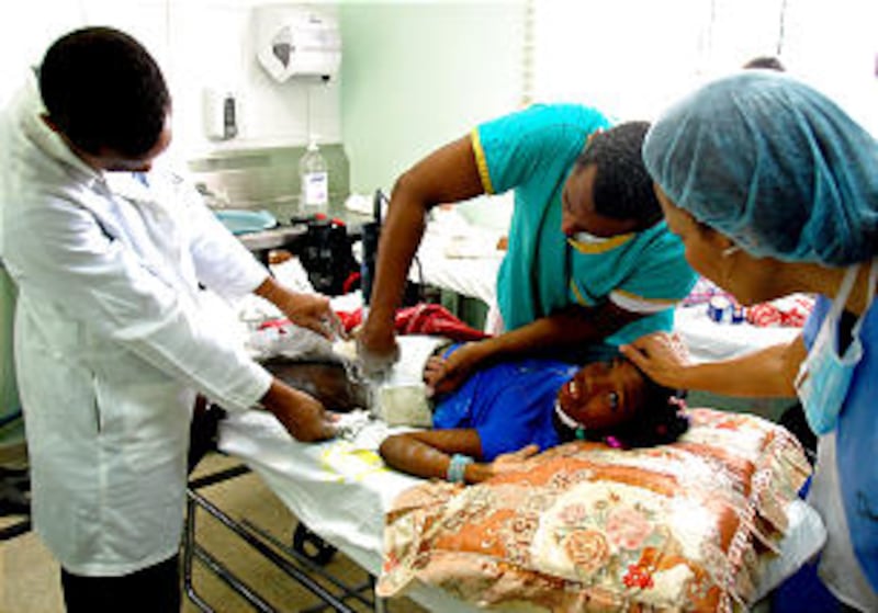 A lower body cast is removed from a young motorcycle accident victim in the Dominican Republic using