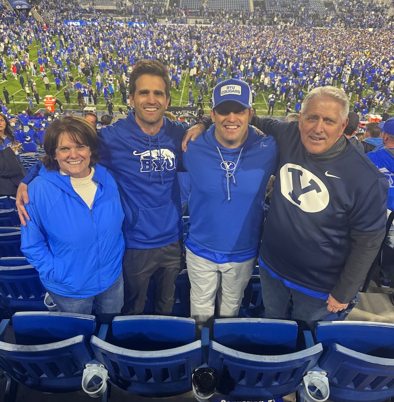 Shawna Edwards, left — composer of "The Miracle," a new addition to Hymns for Home and Church — poses with her husband, John, and two sons at a Brigham Young University football game in fall 2024.