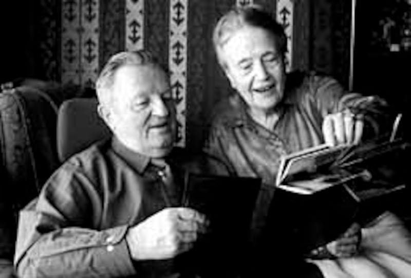 Juliusz and Dorothy Fussek flip through photos taken during their mission to Poland more than 10 yea