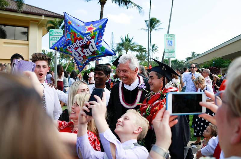 Elder Dieter F. Uchtdorf of the Quorum of the Twelve Apostles stands with his wife, Sister Harriet Uchtdorf, and graduates after BYU-Hawaii commencement exercises on Dec. 14.