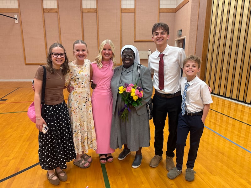 Five young adults and teens pose for a photo with Sister Rosemary Nyirumbe after devotions on March 8, 2026 in Norman, Oklahoma.