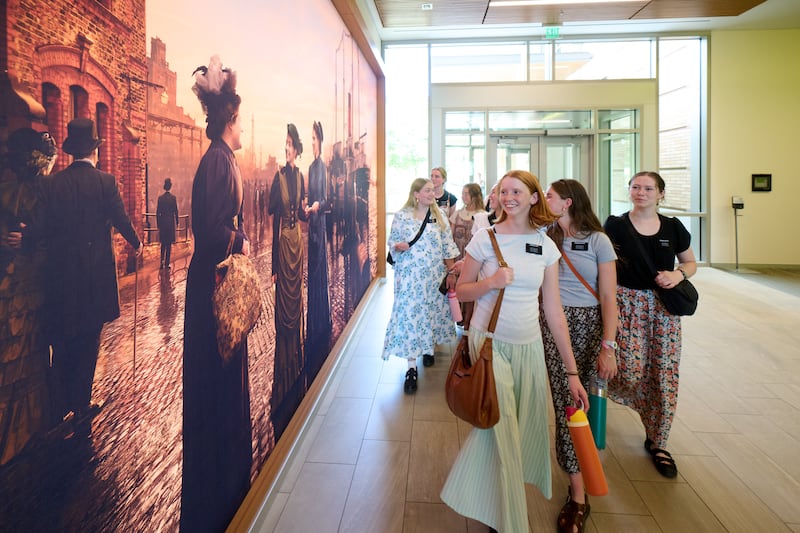 Sister missionaries walk by a new mural depicting the first single sister missionaries of this dispensation, at the Provo Missionary Training Center in Provo, Utah, June 19, 2026.
