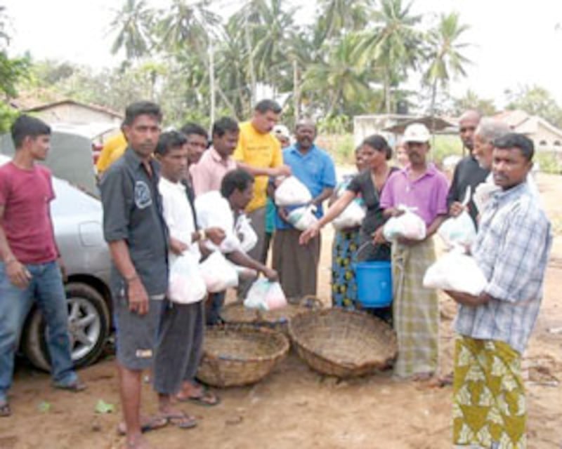 Refugees in Negombo, Sri Lanka, receive relief supplies assembled and distributed by Church members.