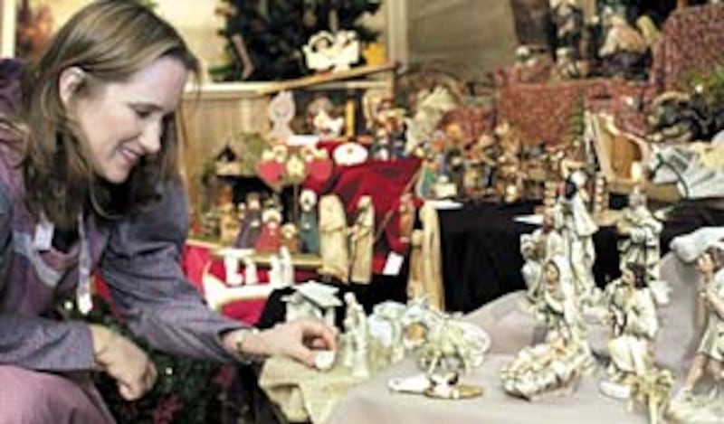 Teresa Chapman examines one of the more than 300 creches on display in 1800s-style schoolhouse and v