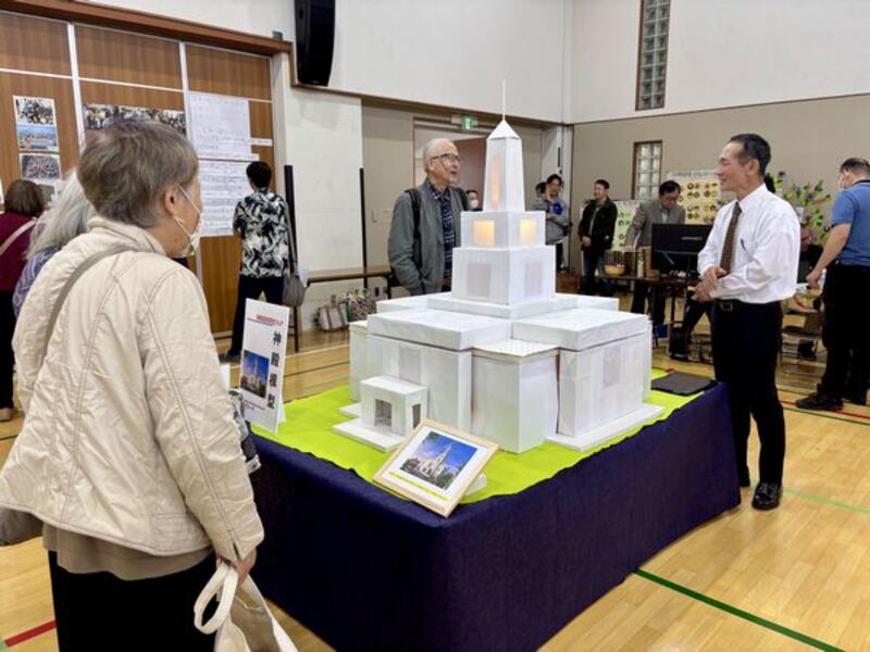 Individuals view a paper model of the future Osaka Japan Temple displayed at a family history fair in Kyoto, Japan, Oct. 25, 2025.