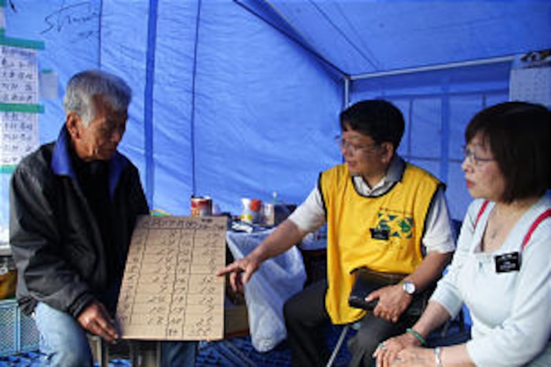 LDS Missionaries, Elder and Sister Wantanabe review needs with fishing village leader, Masahiko Ishi