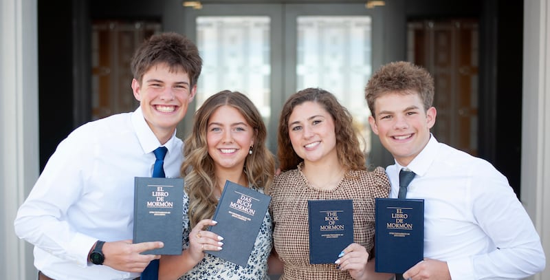 Siblings Eli, Elle, Isabel and Isaac Reid hold up copies of the Book of Mormon in the respective languages they will learn as missionaries.