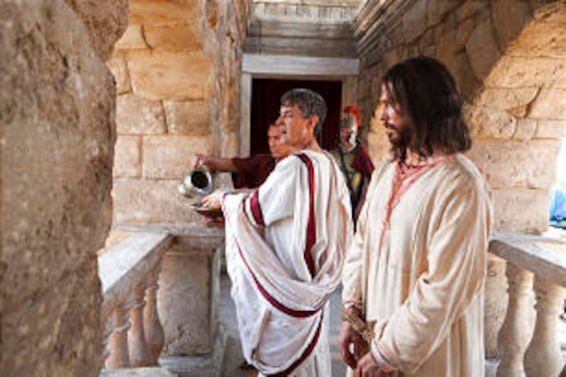 An actor portraying Pontius Pilate washes his hands in front of a crowd that demands the crucifixion