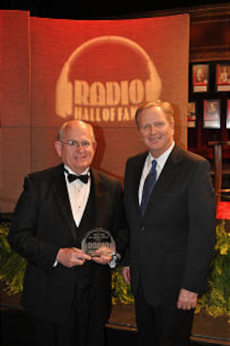 Holding award, director Mack Wilberg stands with program announcer Lloyd Newell following Radio Hall