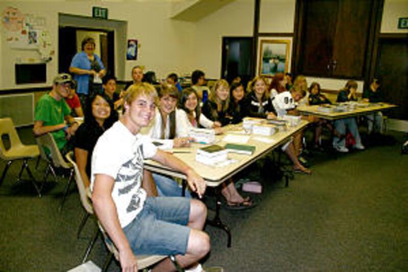 Oakhurst seminary students and their teacher, Kathy Burrow, cheerfully pose during early morning cla