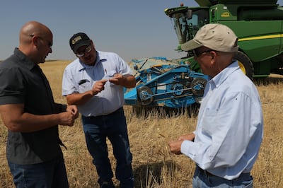From left, President Eldon Pfile, farmer Bill Summers and Church agricultural specialist Wade Sperry