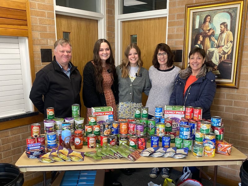 Members of the Bradford Ward in the Leeds England Stake show some of the food collected for JustServe Harvest Appeal donation drive