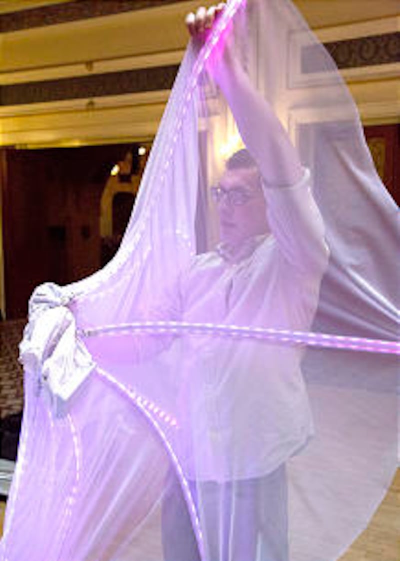 BYU engineering student Franklin Morley inspects one of the light dresses in Blackpool. The BYU Ball