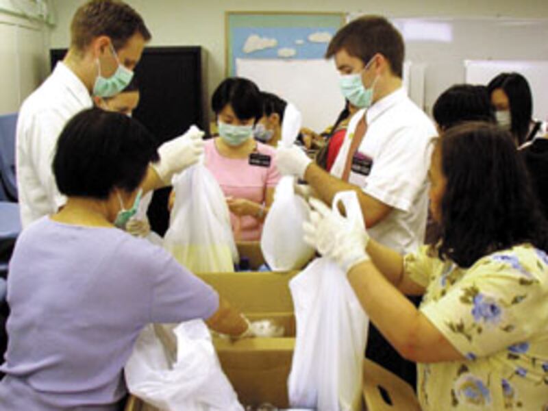 Members and missionaries assemble hygiene kits prior to distribution to needy families.