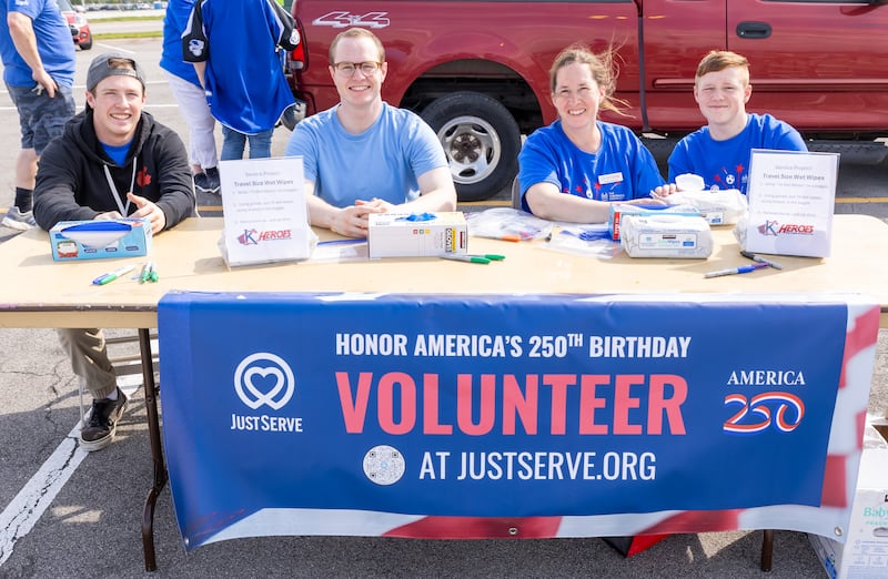 Four volunteers staff the America 250 and JustServe booth at a tailgate event before the Kansas City Royals game in Kansas City, Missouri, Thursday, April 9, 2026.