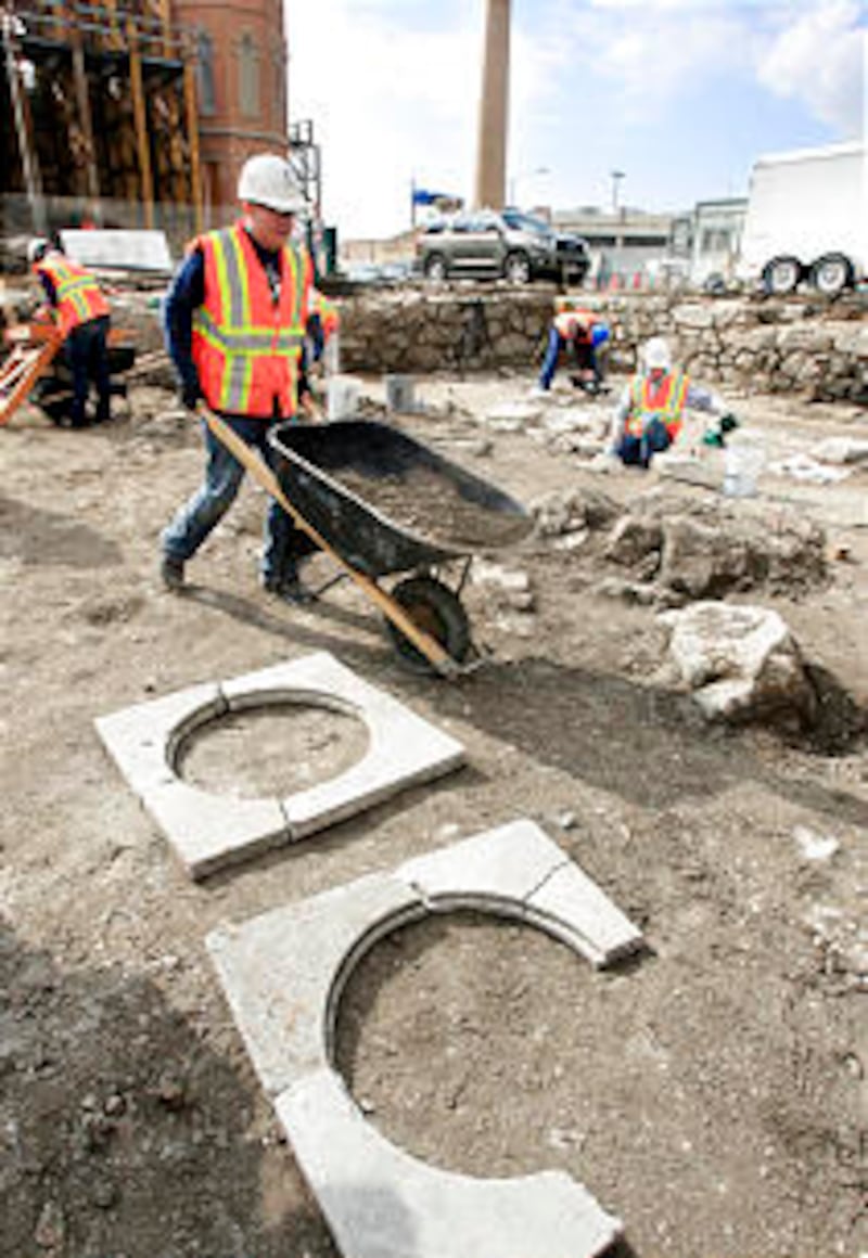 BYU student Ryan Saltzgiver pushes a wheelbarrow past what is believed to be window frames from the
