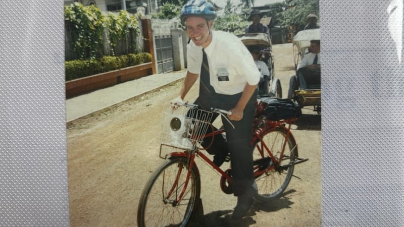 Elder David B.J. Hoare rides his bike on the dirt streets of Phnom Penh, Cambodia, in 1999.