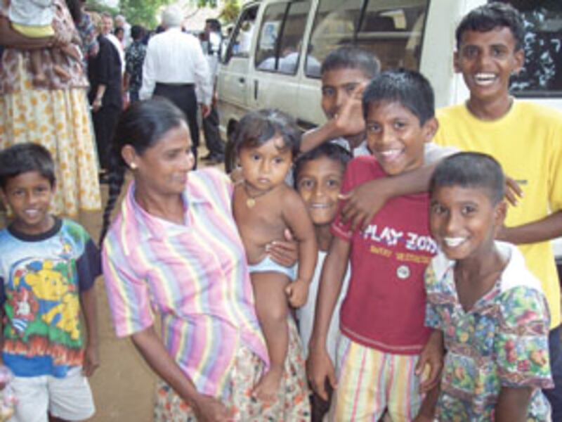 Families in Sri Lanka affected by tsunami gather around van for relief supplies being distributed by