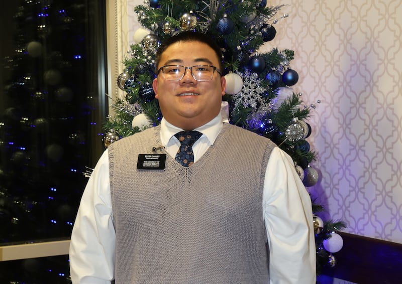 Elder Emmett Oakley, a service missionary from Cedar Falls, Iowa, stands in front of a Christmas tree on Dec. 17, 2025.