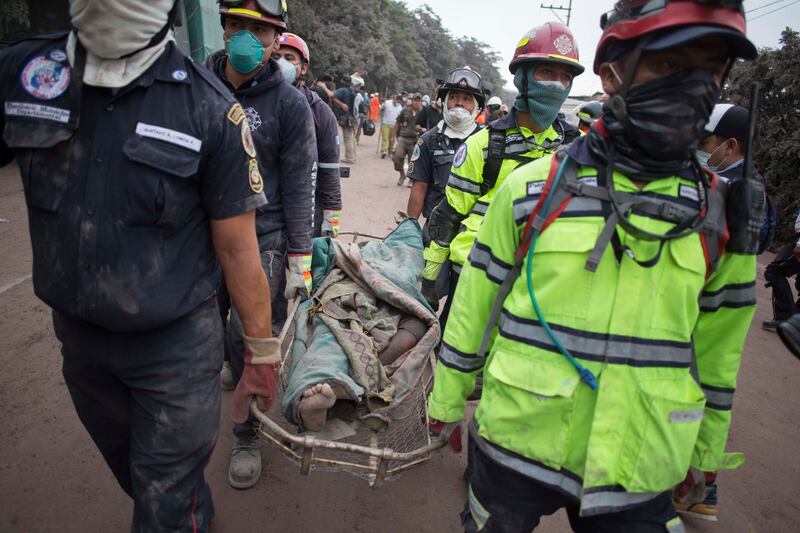 Firefighters carry a body recovered near the Volcan de Fuego, or "Volcano of Fire," in Escuintla, Gu