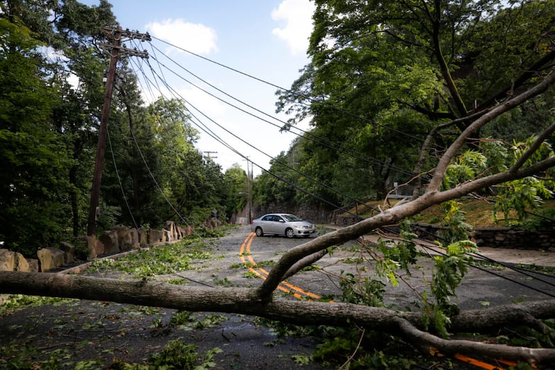 Debris and power lines lie in a road brought down by high winds and rain, Tuesday, Aug. 4, 2020, in Edgewater, N.J. Tropical Storm Isaias spawned tornadoes and dumped rain during an inland march up the U.S. East Coast, including New Jersey, on Tuesday after making landfall as a hurricane along the North Carolina coast. (AP Photo/John Minchillo)