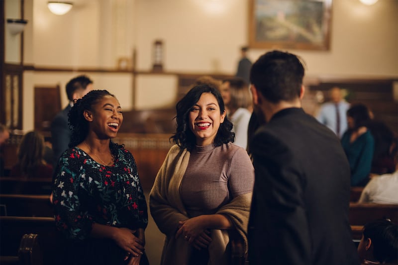 Members of a congregation visit with each other.