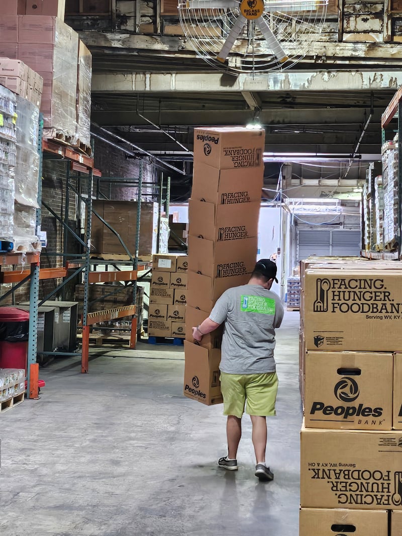 Elder Welch carries a stack of boxes at the Facing Hunger Food Bank in Huntington, West Virginia on ______.