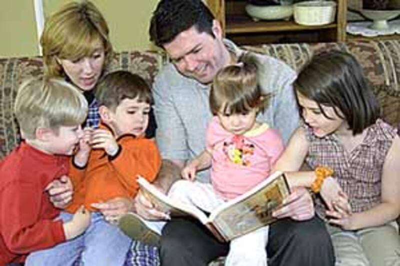 Allison and Ricardo Villarini read to their children, from left, Brandon Gabriel, 6; Daniel Alexande