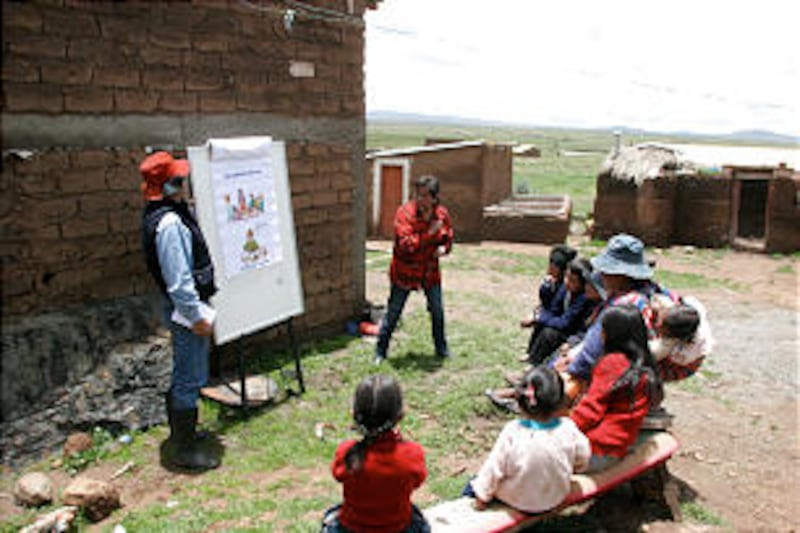 Benson Institute workers Gustavo Vargas, left, and Elizabeth Garcia teach the Ignacio Choque family