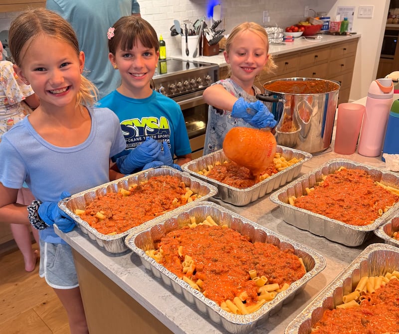 From left to right, Sadie Coons, Adeline King and Hannah Shafer help their ward girls activity days group prepare meals to take to families displaced by wildfires in Spokane, Washington, in August 2026.