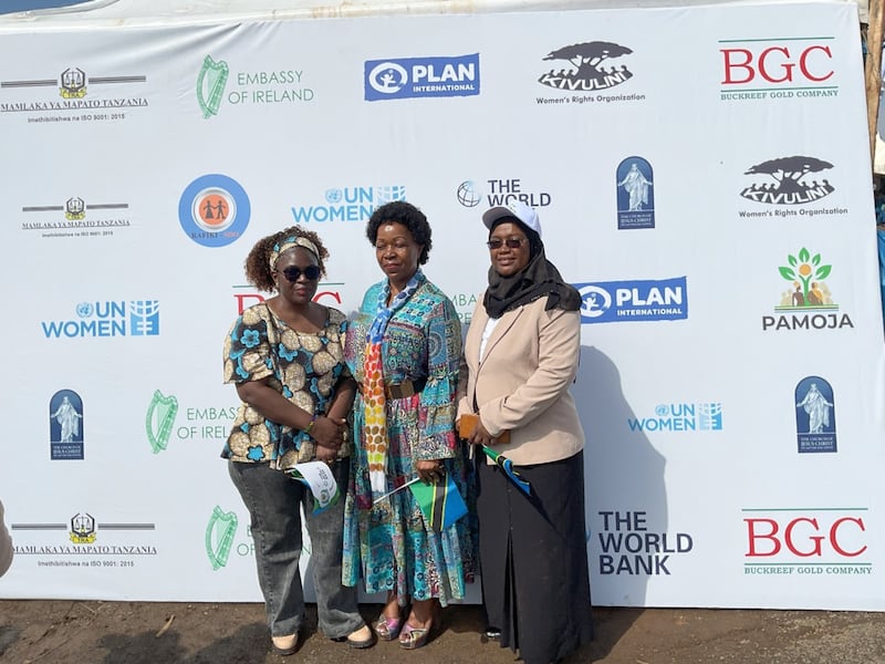 Sister Judith Spendi the Church’s Area Organization Adviser (center) poses for a photo with ministry officials in front of a banner displaying names of organizations that supported the ministry in the preparations for the International Women’s Day celebrations on March 8, 2026 in Geita, Tanzania.