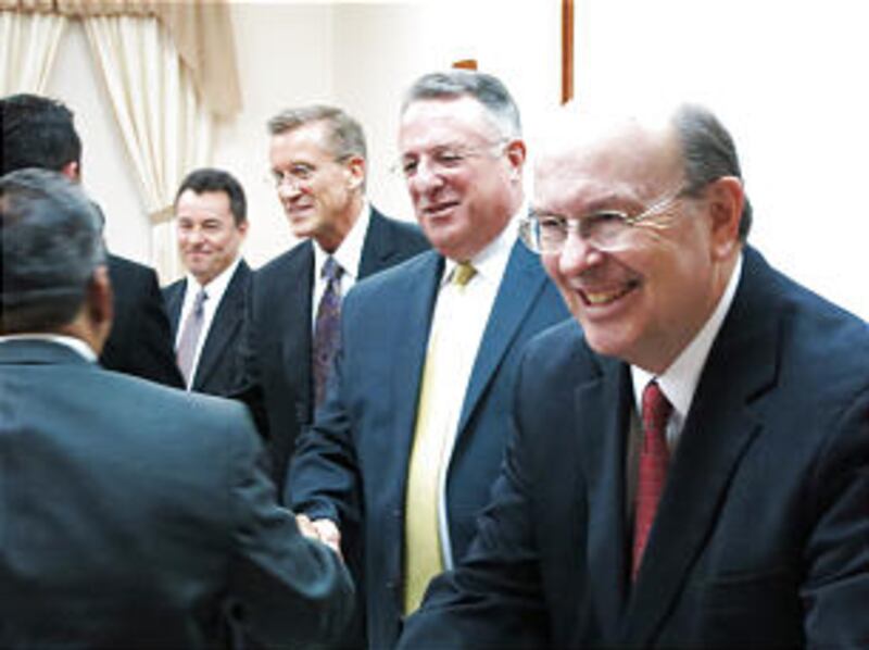 From right, Elder Quentin L. Cook, Elder Ulisses Soares and Elder Kevin R. Duncan shake hands with m
