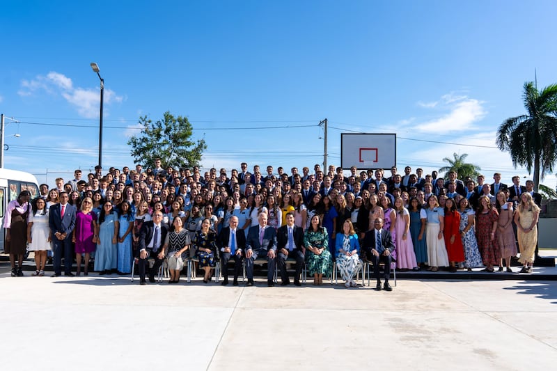 Elder Ronald A. Rasband of the Quorum of the Twelve Apostles and other leaders pose for a picture with missionaries serving in the Dominican Republic.