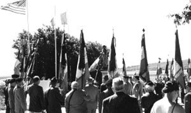 French veterans carry lances with flags attached at monument site in Taillefontaine, France, on June