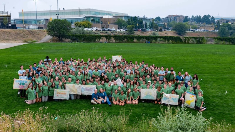 Dozens of youth pose for a group photo on a large field at the For the Strength of Youth conference in Kamloops, British Columbia, Canada, in August 2026.