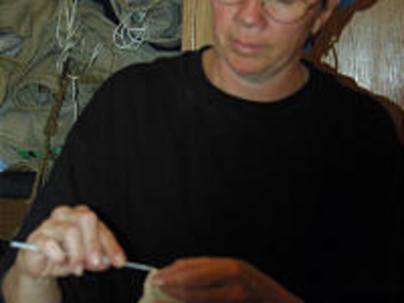 Anna Rollap knits bandages while on board the Christian Radich.