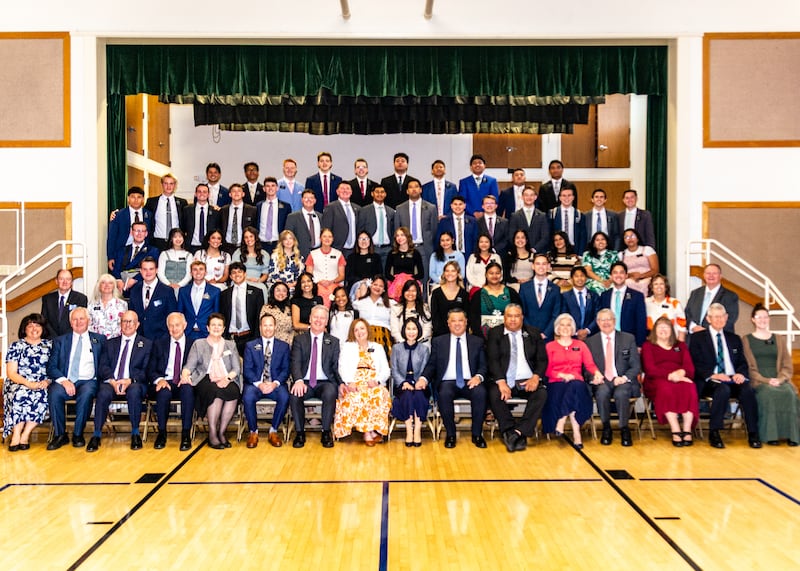Missionaries in the California Oakland/San Francisco Mission take a large group photo by a chapel stage during a zone conference in 2025.