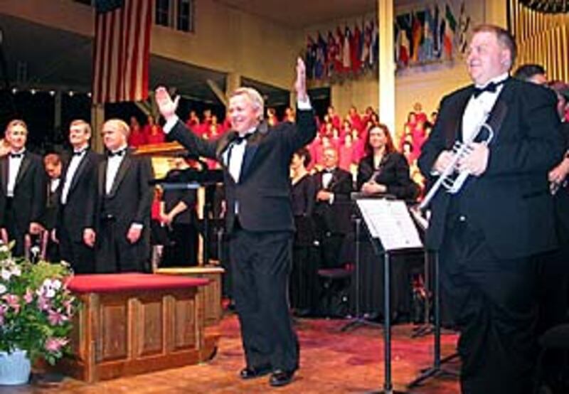 Choir director Craig Jessop salutes audience gathered for concert at Chautauqua Institution. Thousan