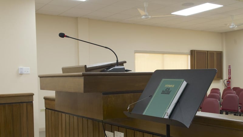 A hymnbook and music stand rest next to the pulpit in a new meetinghouse for members of the Curepe Ward in the Port of Spain Trinidad Stake of The Church of Jesus Christ of Latter-day Saints in Arima, Trinidad and Tobago, in July 2026.