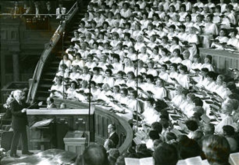 Former director Jerold Ottley conducts choir during general conference session in 1989. In accepting