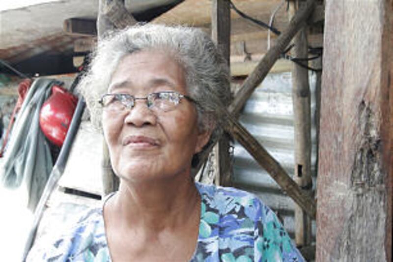 Editha Enghoy Malda stands outside her new home, built by the Church.