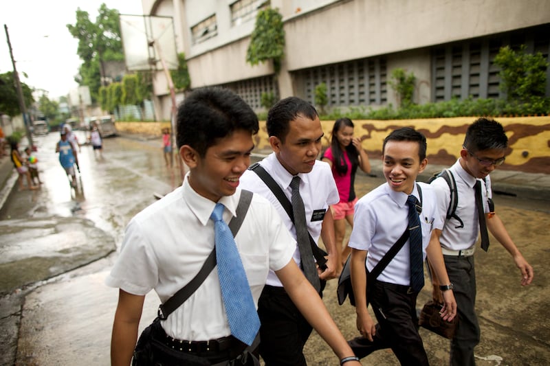 A group of missionaries walk together along a street in the Philippines in 2025.