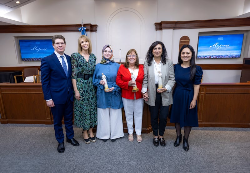 Elder Alan R. Walker, Sister Inés Walker, Sümeyra Nur Korkur, Cecilia Blanco de Di Lascio, Silvina Chemen and Jorgelina Benavidez stand together for a picture after the "Women who Illuminate" ceremony in Buenos Aires, Argentina, March 19, 2026.
