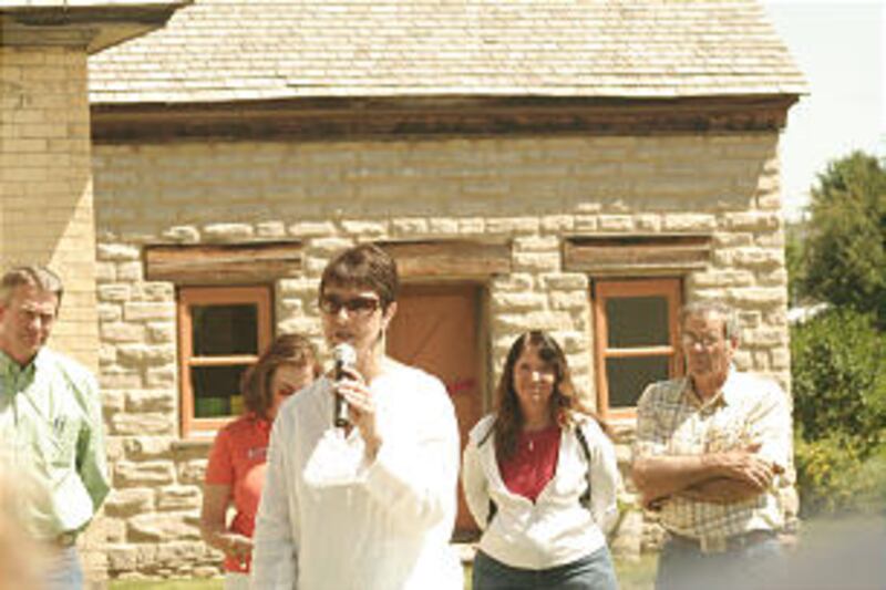 Barbara Taylor, center, comments on newly restored pioneer homes in Franklin. Idaho Lt. Gov. Brad Li
